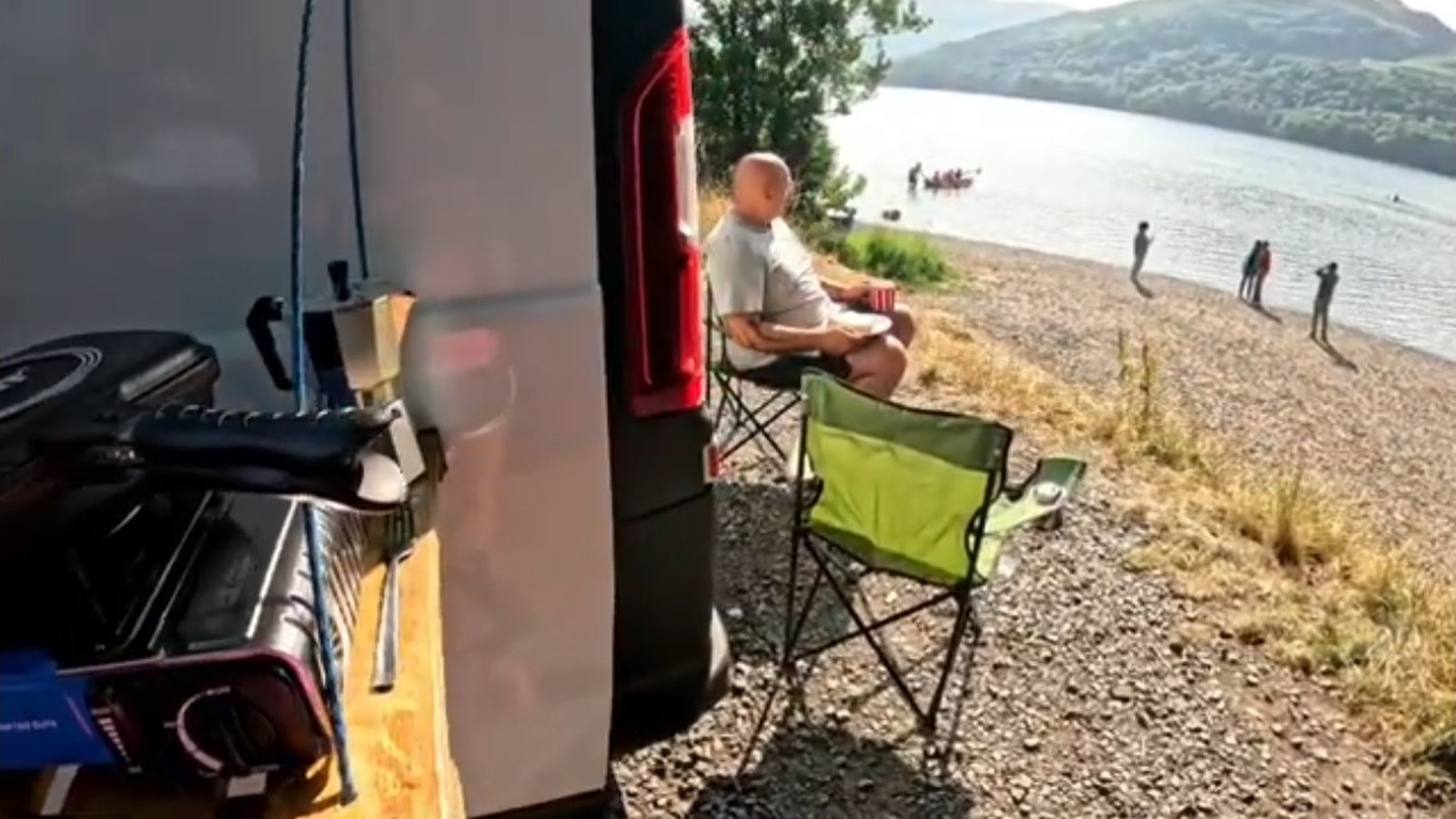 White campervan parked beside a lake during a van life trip